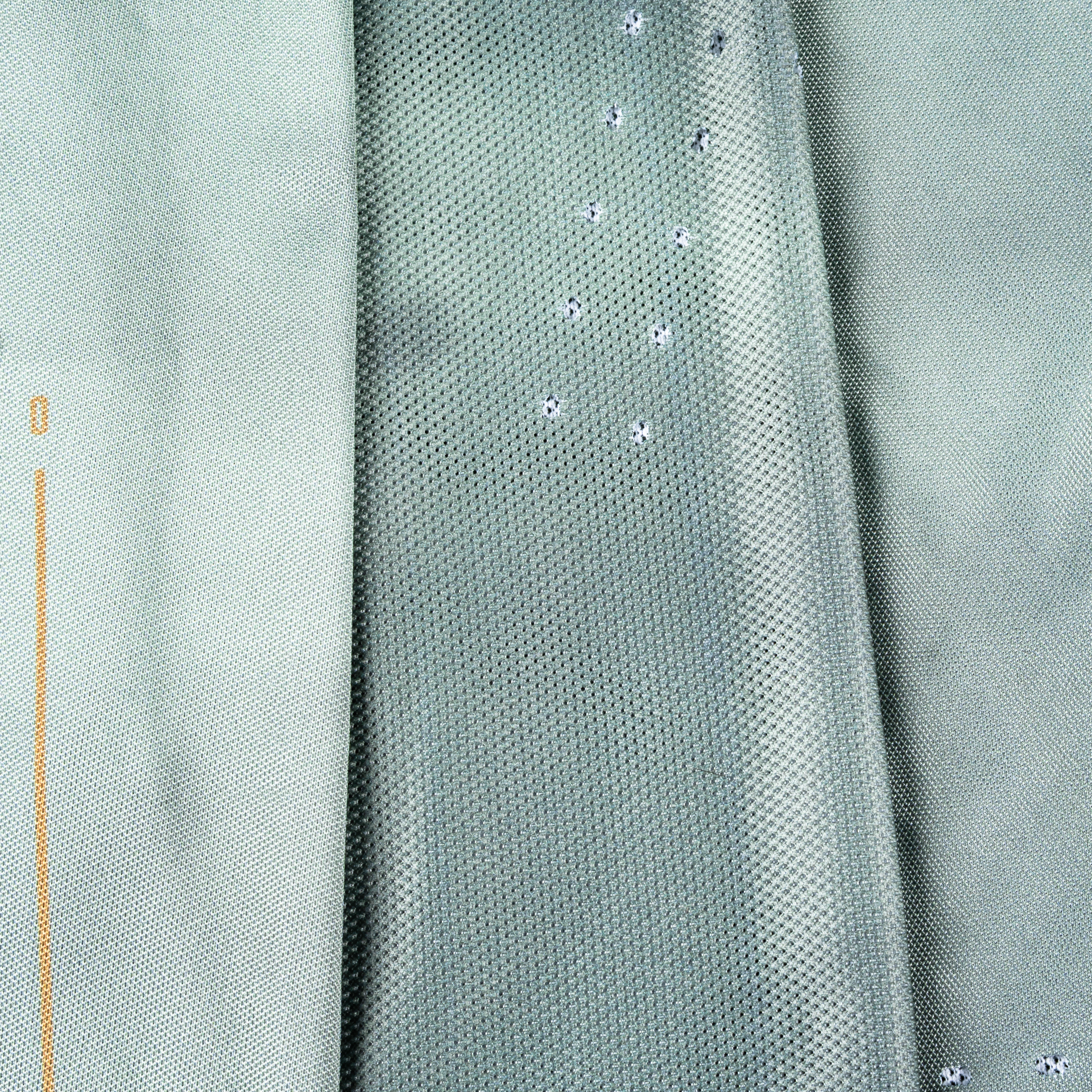 Close-up of a textured fabric with a subtle pattern on a light green background